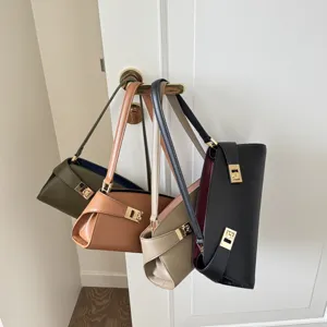 Detailed view of genuine leather baguette shoulder bags in multiple colors hanging on door.