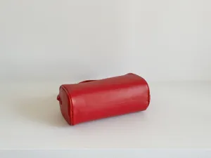 Sac cylindrique rouge minimaliste en cuir vue de détail, design rétro chic et élégant.
