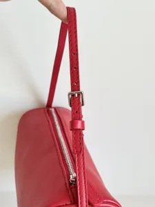 Sac à bandoulière cylindrique en cuir rouge compact sac tonneau minimaliste détail