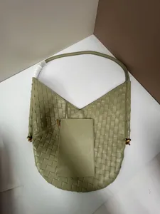 Detailed closeup view of the light green woven leather shoulder tote bag with structured pouch.