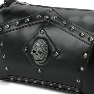 Vista detallada de bolso bandolera punk negro con cráneo metálico y tachuelas.