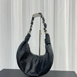 Black crescent hobo shoulder bag with shiny textured leather and metallic chain strap design.