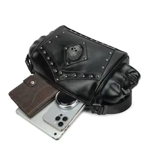 Bolso de hombro de cuero negro estilo punk con calavera en relieve y tachuelas metálicas.
