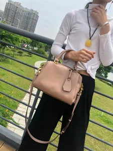 Vue détaillée d'un sac Boston en cuir rose, mettant en valeur la texture et la quincaillerie.