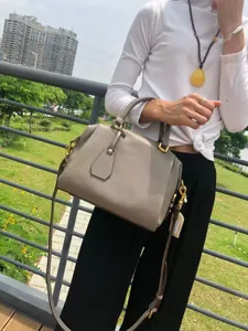 Vue détail du sac à main Boston en cuir véritable gris, avec des poignées confortables et sangle.
