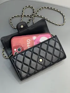 Black quilted leather chain phone bag detail, showing classic diamond pattern and metal strap.