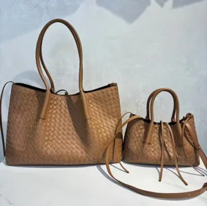 Detailed view of the large and small brown leather woven tote bags with double handles.