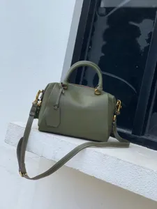 Détail de sac Boston en cuir vert olive, sac à main poignée supérieure avec bandoulière.