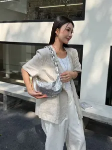 Detailed shot of a stylish silver sequin hobo bag with metallic chain, chic shoulder underarm purse.
