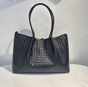Close up view of the classic black woven leather tote bag detail, showcasing premium texture.