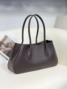 Close-up detail shot of the dark brown leather tote bag showing fine texture and dual straps.