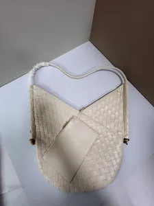 Detailed view of cream white woven leather shoulder bag with chic V-cut design and pouch.