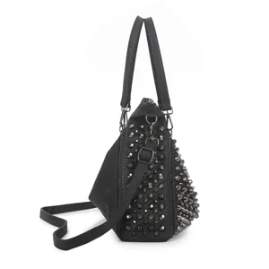 Detalle de bolso negro estilo punk con tachuelas metálicas y diseño de cuero elegante.