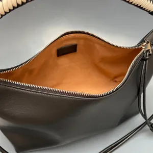 Black leather shoulder bag with woven handle and zipper closure, stylish daily tote purse.