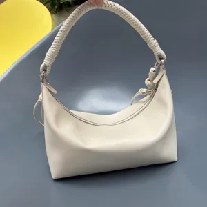 Elegant white leather shoulder bag with unique hand-braided handle and secure zip closure.