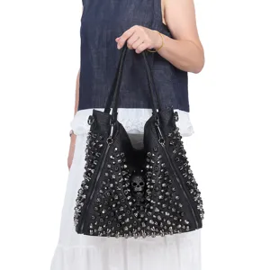 Bolso tote de cuero negro estilo punk con tachuelas metálicas y detalle de calavera.