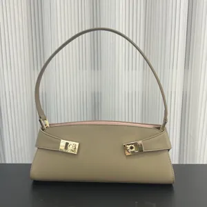 Taupe leather baguette shoulder bag detail showcasing elegant gold metal hardware design.