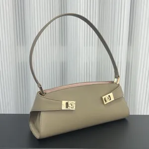 Chic taupe leather shoulder bag for women, elegant baguette handbag with gold-tone hardware.