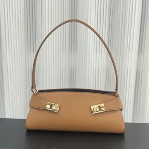 Detail view of stylish tan leather shoulder bag with chic gold hardware buckle design.