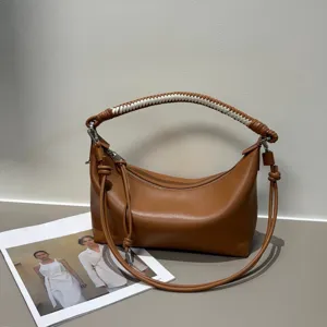 Brown leather shoulder bag with hand-woven handle and stylish dumpling shape for women daily use.