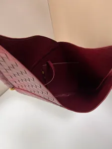 Close-up detail of the luxury woven leather tote bag interior and pouch texture design.