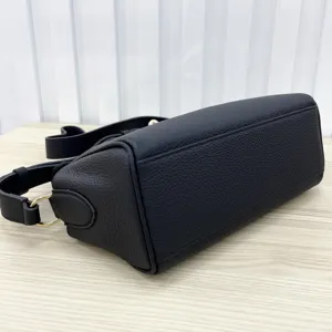 Black leather crossbody bag detail view showing fine texture and durable hardware finish.