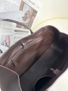 Premium brown leather tote bag interior detail, spacious genuine leather shoulder bag for women.
