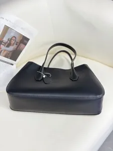 Close-up view of the black genuine leather tote bag, showcasing fine texture and style.