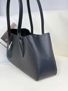 Detail view of black genuine leather tote shoulder bag, sleek minimalist design for women.