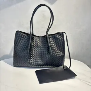 Black genuine leather woven tote bag detail showing large capacity, dual handles and pouch.