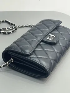 Quilted leather chain shoulder bag detail, elegant black mini crossbody bag close view.