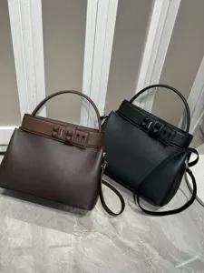 Detailed view of luxury leather handbag showcasing fine texture, pyramid stud closure, and handle.