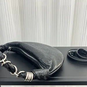 Detailed view of black genuine leather crescent hobo bag with stylish metal chain strap.