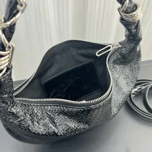 Close-up of black textured leather hobo bag zipper and interior lining detail shot.