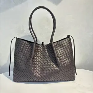 Dark brown leather woven tote bag detail, featuring classic intrecciato craftsmanship.