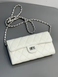 White quilted leather chain bag detail shot, classic turn lock and elegant shoulder strap design.
