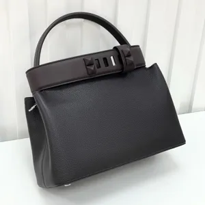 Detail view of the premium genuine leather handbag with chic pyramid stud belt and top handle.