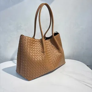 Detailed view of the brown leather woven tote bag, elegant large capacity shoulder handbag.