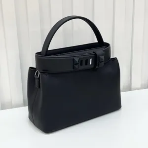 Black leather top handle bag with pyramid stud belt detail, chic women's shoulder handbag.