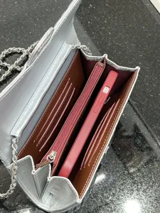 Interior detail of silver metallic chain crossbody bag with multi card slots and phone pocket.