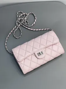 Close-up detail of the pink quilted leather crossbody bag featuring silver chain strap.