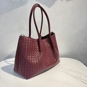 Detailed view of the luxury burgundy woven leather tote bag, elegant handcrafted shoulder design.