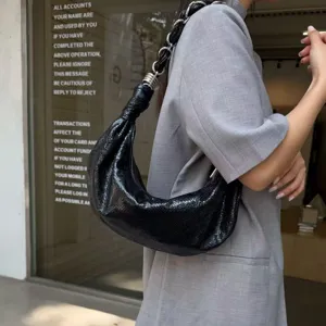 Stylish black leather crescent shoulder bag with chain strap, trendy hobo bag for women daily.