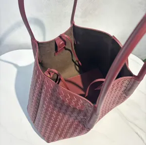 Detailed view of burgundy woven leather tote bag interior and premium texture closeup.