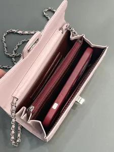Detailed view of pink quilted leather chain bag interior, showing card slots and storage space.