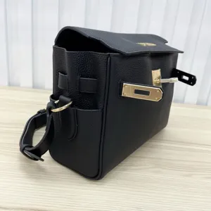 Black genuine leather Kelly messenger bag with metal lock hardware and shoulder strap detail.