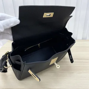 Detailed view of the black leather Kelly messenger bag showcasing interior space and hardware.