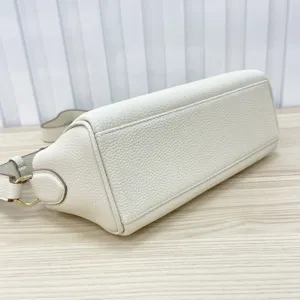 Detailed view of the white top-layer cowhide leather handbag bottom and side stitching design.