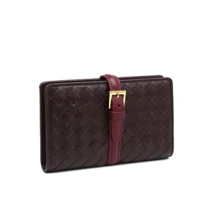 Vista dettagliata del portafoglio in pelle intrecciata marrone scuro con cinturino bordeaux.