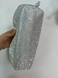 Silver rhinestone evening bag detail, sparkling crystal pleated clutch surface texture.